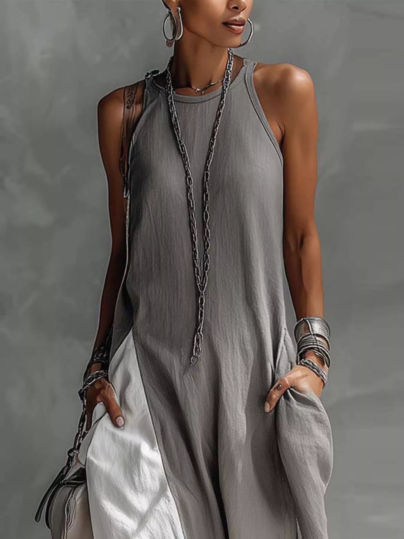 Woman wearing a gray sleeveless dress with a plain background