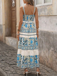 Woman wearing a floral dress with blue and white patterns on a cobblestone street.