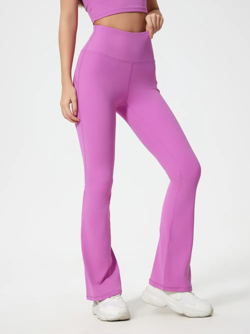 Person wearing pink high-waisted leggings on a white background