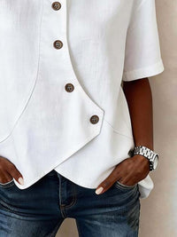 White button-up shirt and blue jeans worn by a person against a neutral background