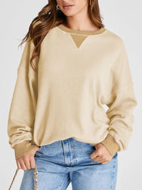 Beige sweater worn by a person on a white background