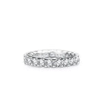 A silver diamond eternity ring with a continuous row of round-cut diamonds on a white background.