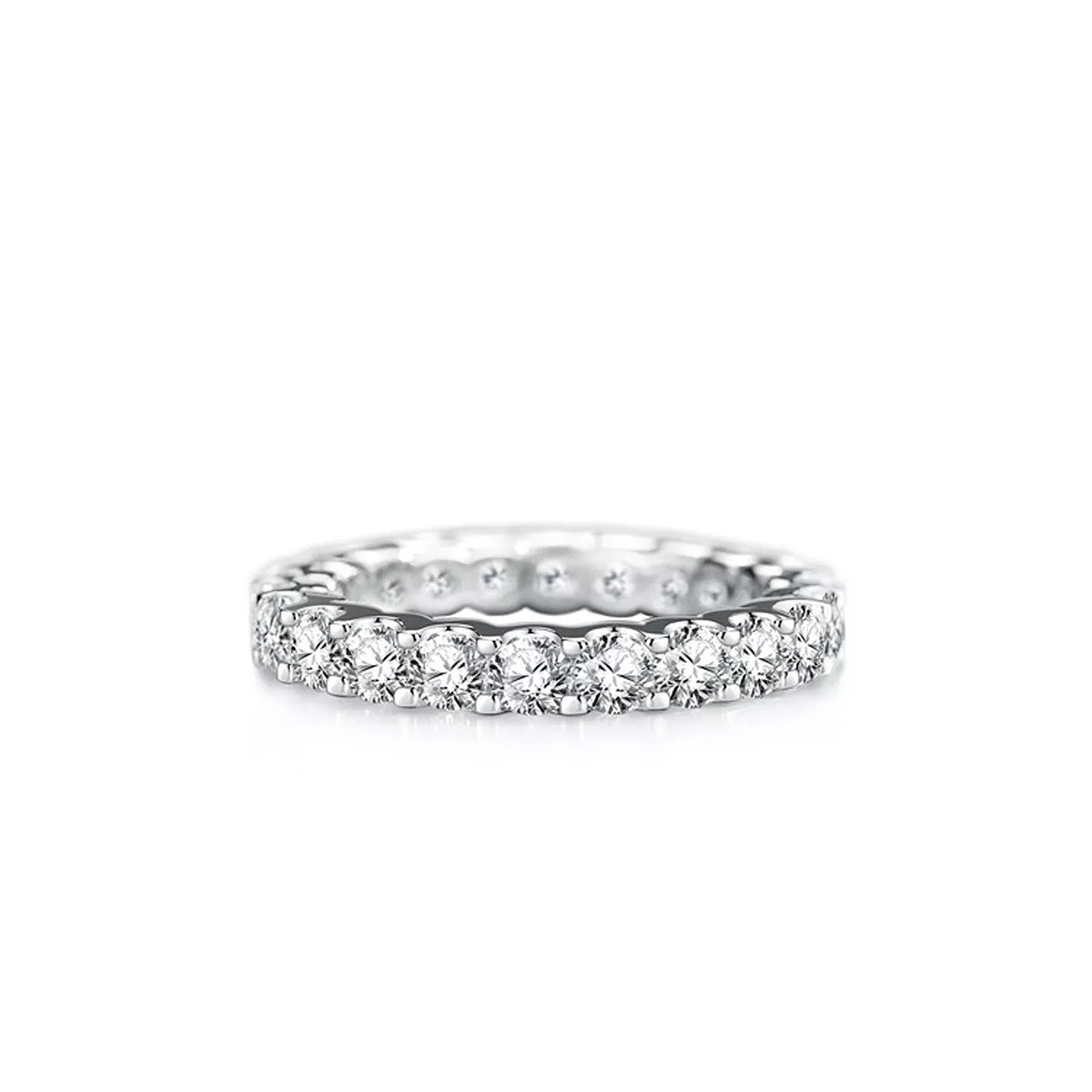 A silver diamond eternity ring with a continuous row of round-cut diamonds on a white background.