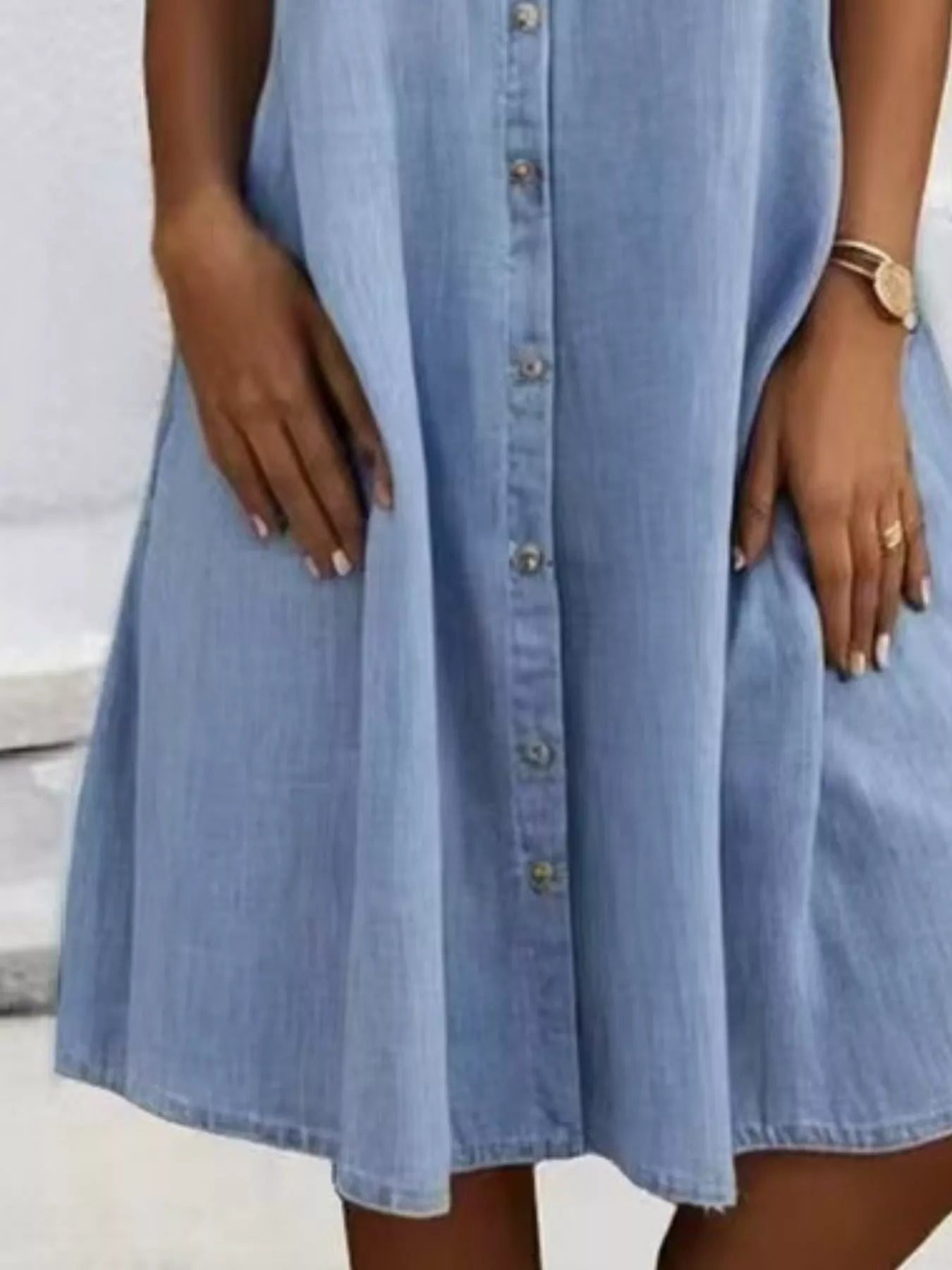 Light blue denim dress worn by a person with a neutral background