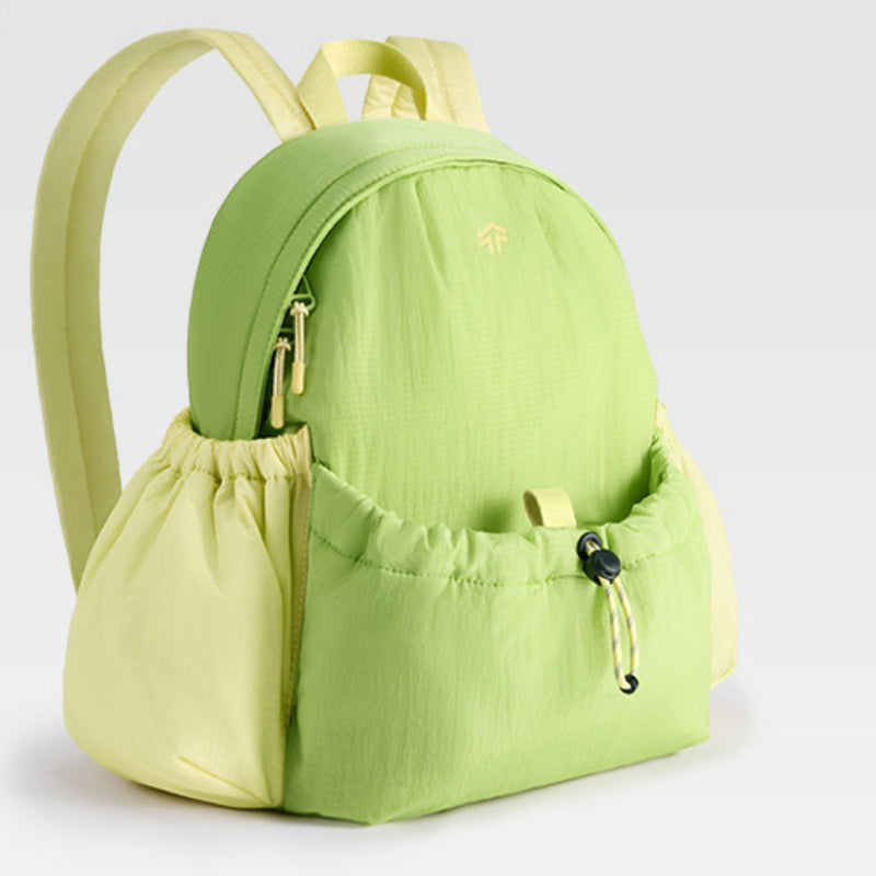 Green backpack with a drawstring pocket on a light gray background