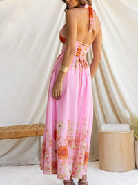 Woman wearing a pink floral dress against a white curtain background