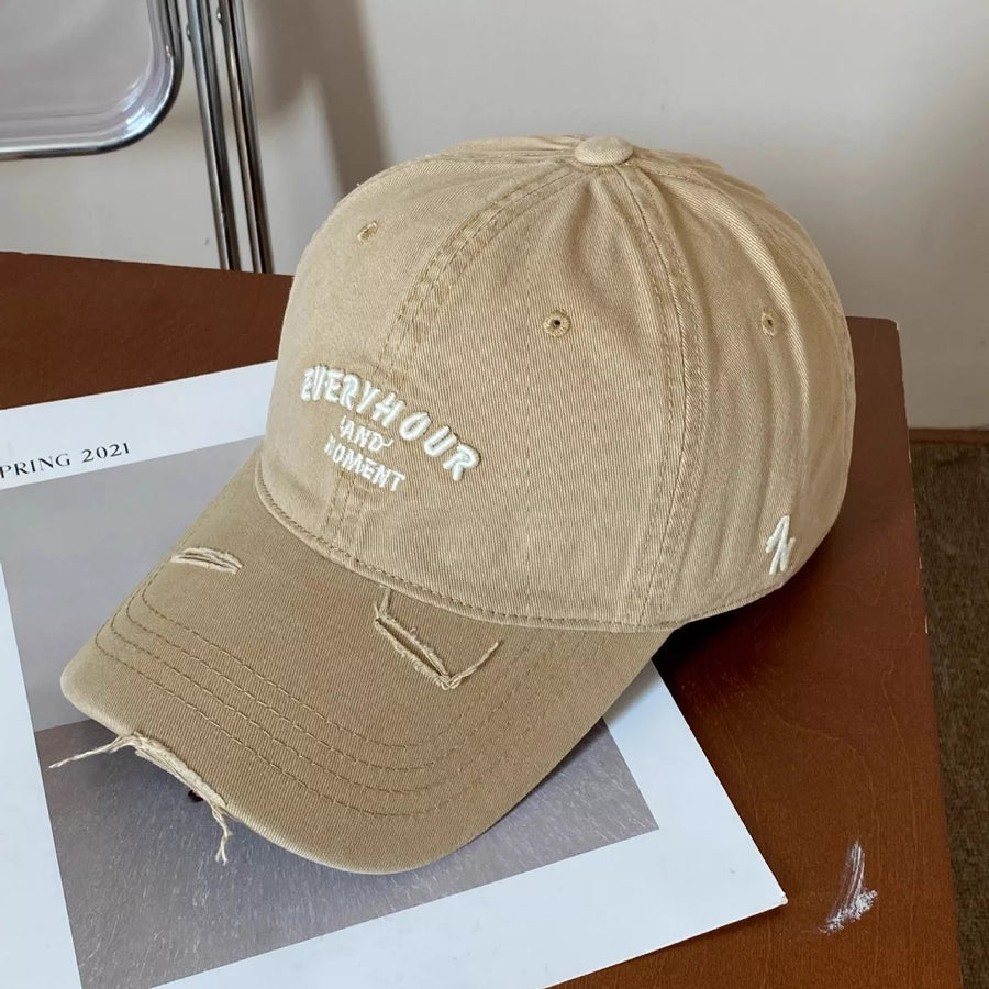 Beige cap with text on a wooden surface