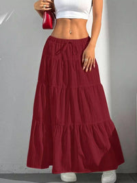 Red tiered skirt worn by a person on a plain background