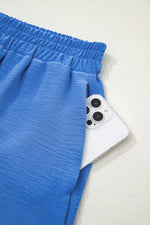 Blue shorts with a white device featuring camera lenses on a light gray background