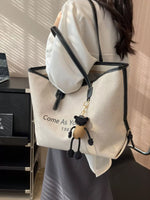 Person wearing a white backpack with a small bag over one shoulder, in an indoor setting.