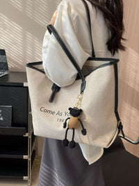 Person wearing a white backpack with a small bag over one shoulder, in an indoor setting.