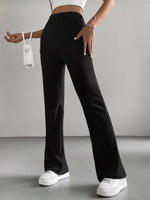 Person wearing black ribbed wide-leg pants with a white top and white sneakers on a gray background