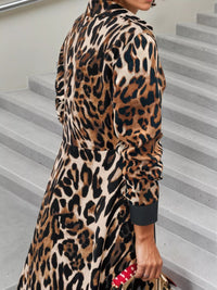 Person wearing a leopard print dress standing on a staircase.