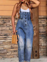 Person wearing a denim jumpsuit against a stone wall background