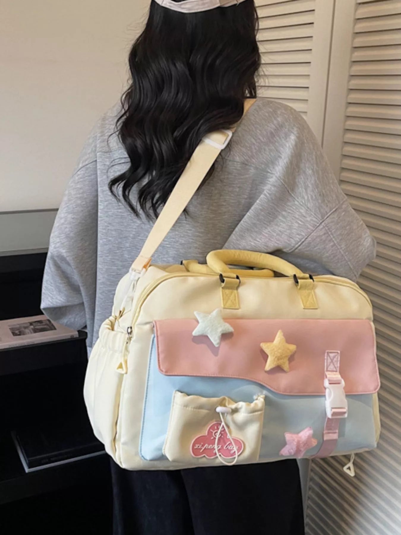 Person carrying a pastel-colored bag with star and bow designs.