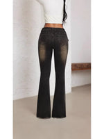 Black flared jeans worn by a person against a plain background