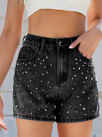 Black denim shorts with rhinestone embellishments worn by a person.