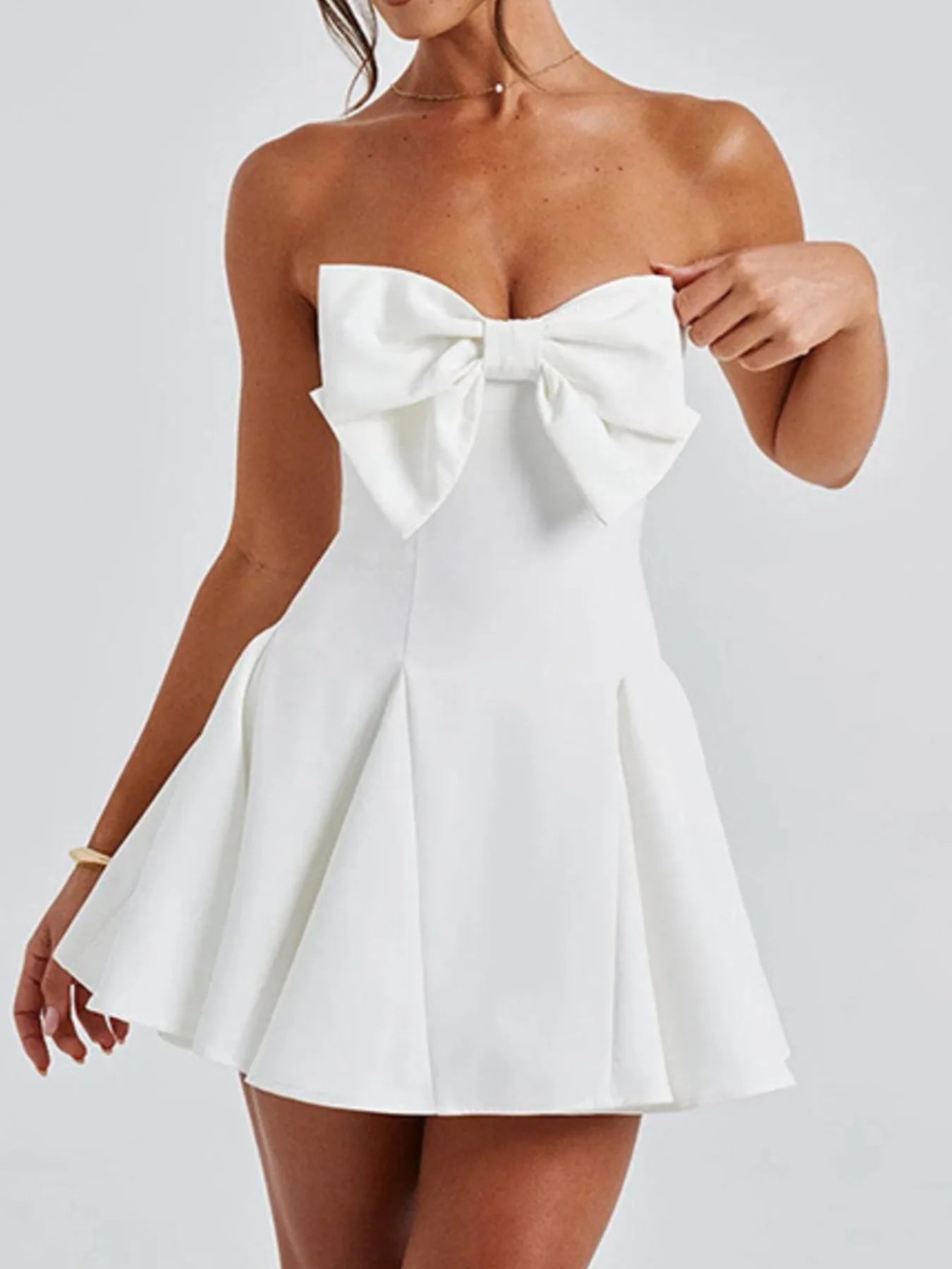 White strapless dress with a large bow detail on a white background