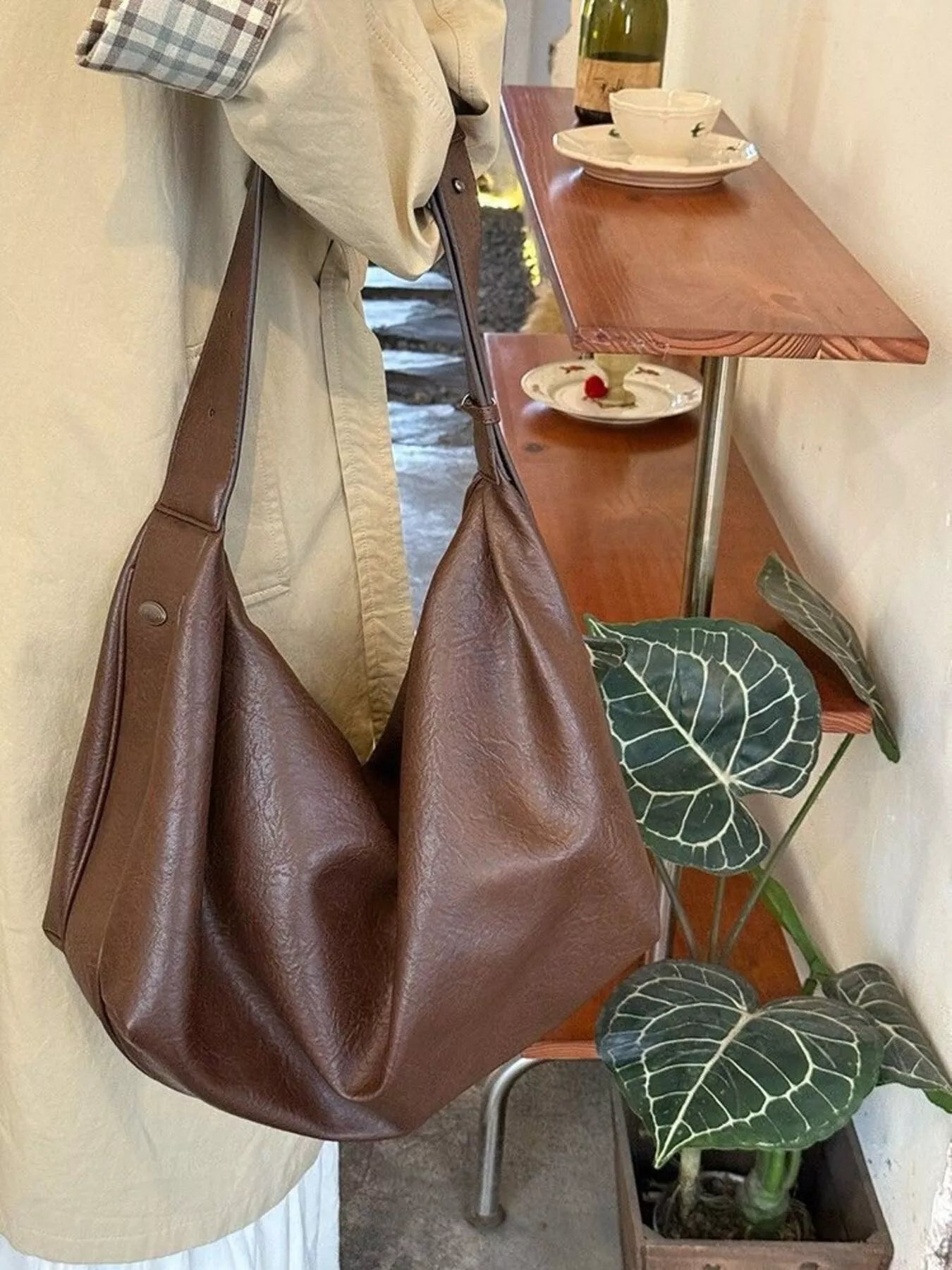 Brown leather bag hanging on a chair with a cafe setting in the background