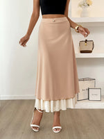 Woman wearing a beige skirt with a white bottom section, standing indoors.