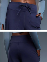 Navy blue athletic pants with a drawstring waistband on a gray background