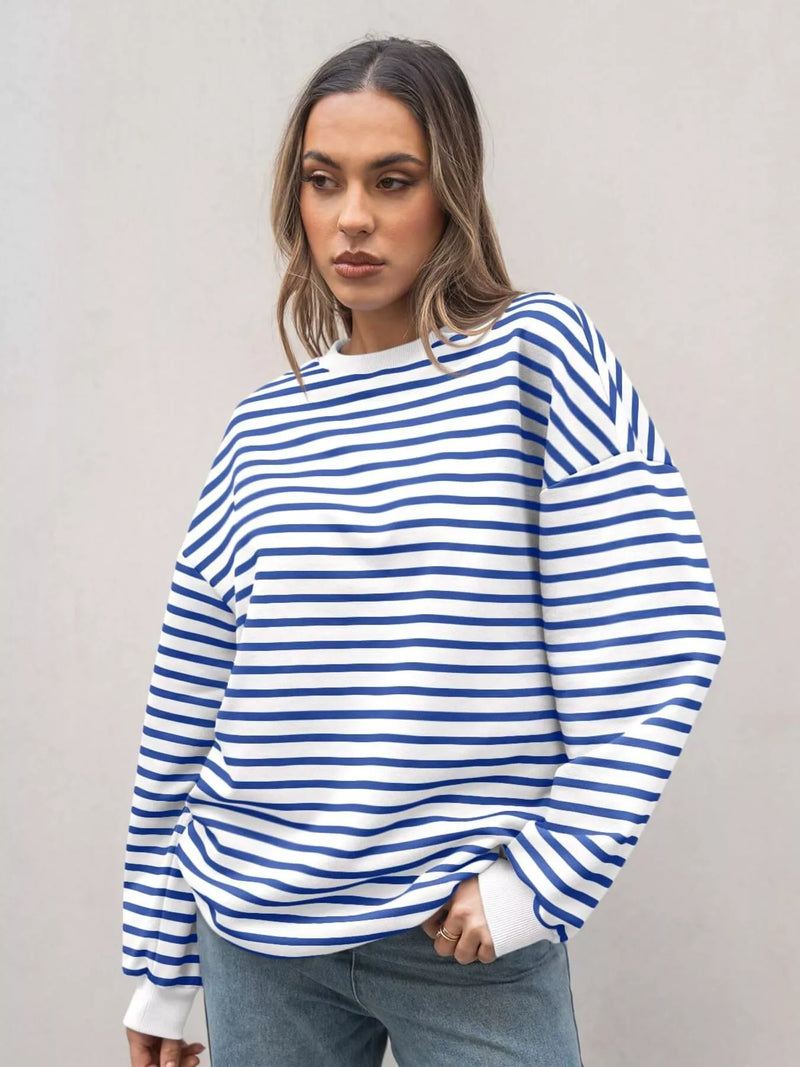 Woman wearing a blue and white striped sweater against a plain background