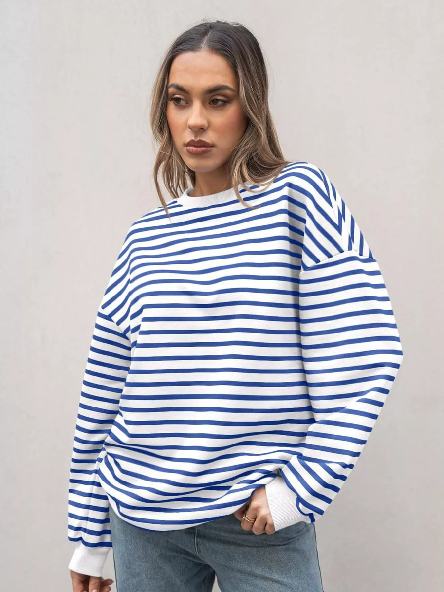 Woman wearing a blue and white striped sweater against a plain background