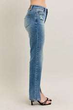 Blue jeans worn by a person on a plain background
