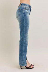 Blue jeans worn by a person on a plain background