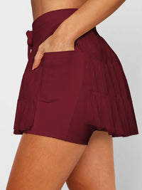 Maroon shorts worn by a person on a plain background