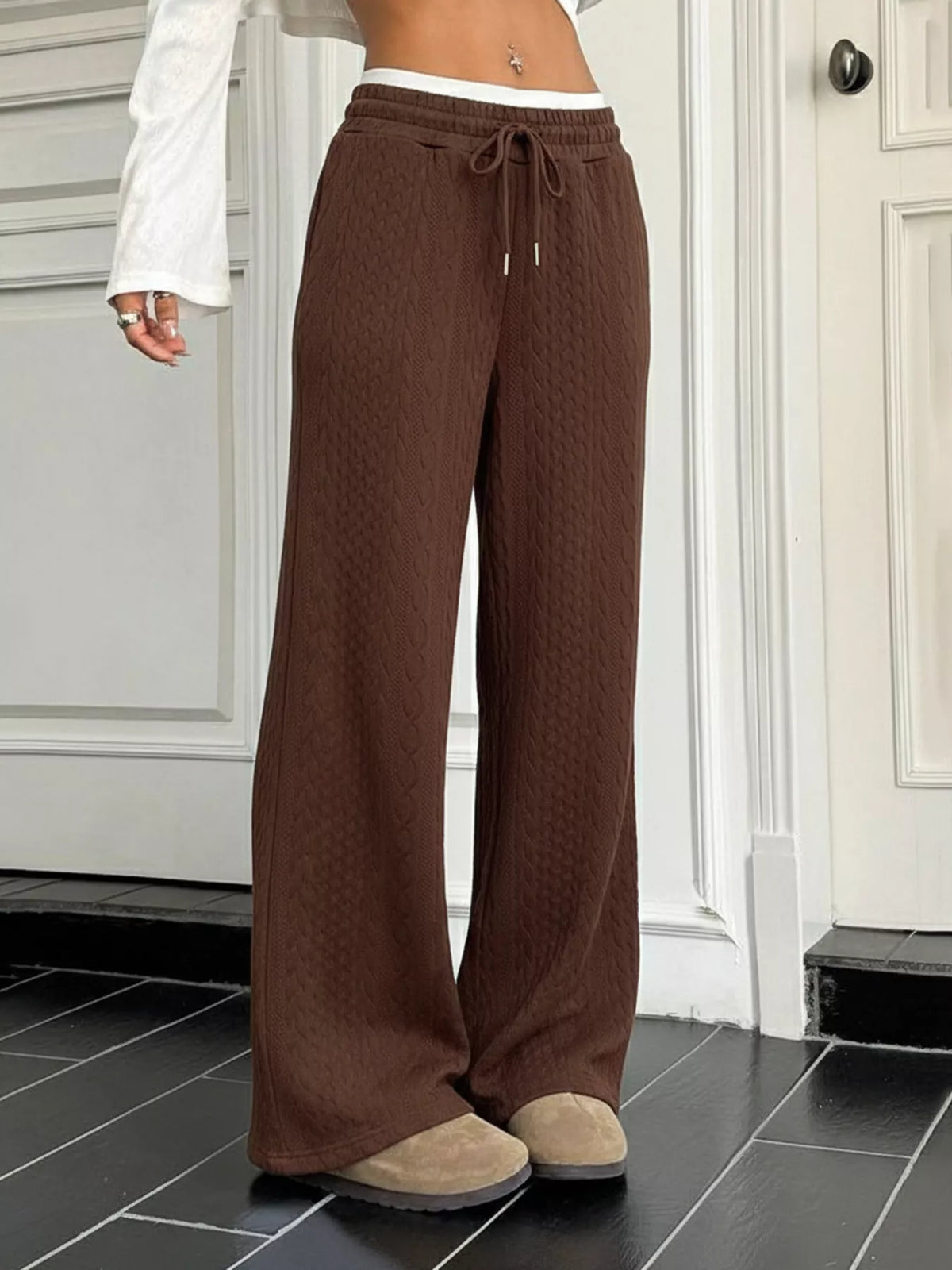 Brown wide-leg pants worn by a person indoors on a tiled floor.