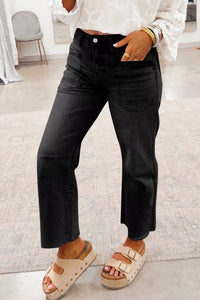 Person wearing black pants and sandals in a room with a chair and rug.