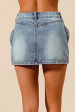 Light blue denim skirt worn by a person on a beige background