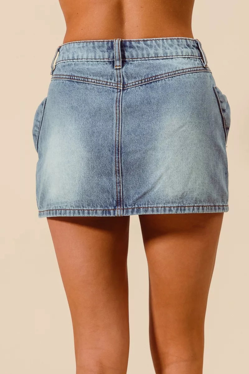 Light blue denim skirt worn by a person on a beige background