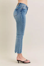 Light blue jeans worn by a person on a beige background