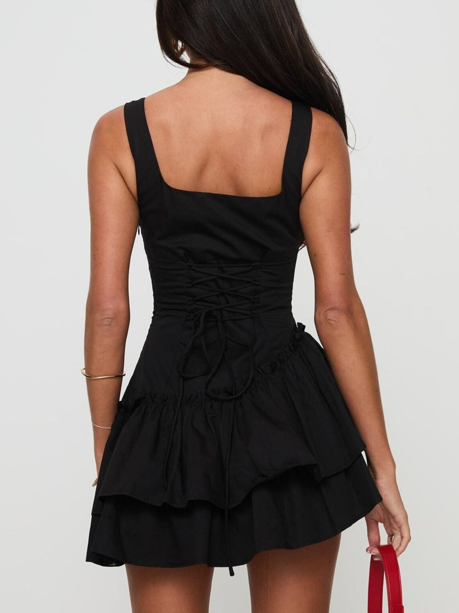 Black dress with ruffled layers on a plain background