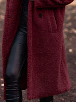Person wearing a burgundy coat with a blurred background