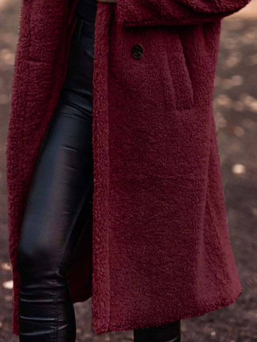 Person wearing a burgundy coat with a blurred background