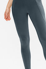 Gray leggings worn by a person on a white background