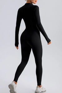 Person wearing a black bodysuit on a light gray background
