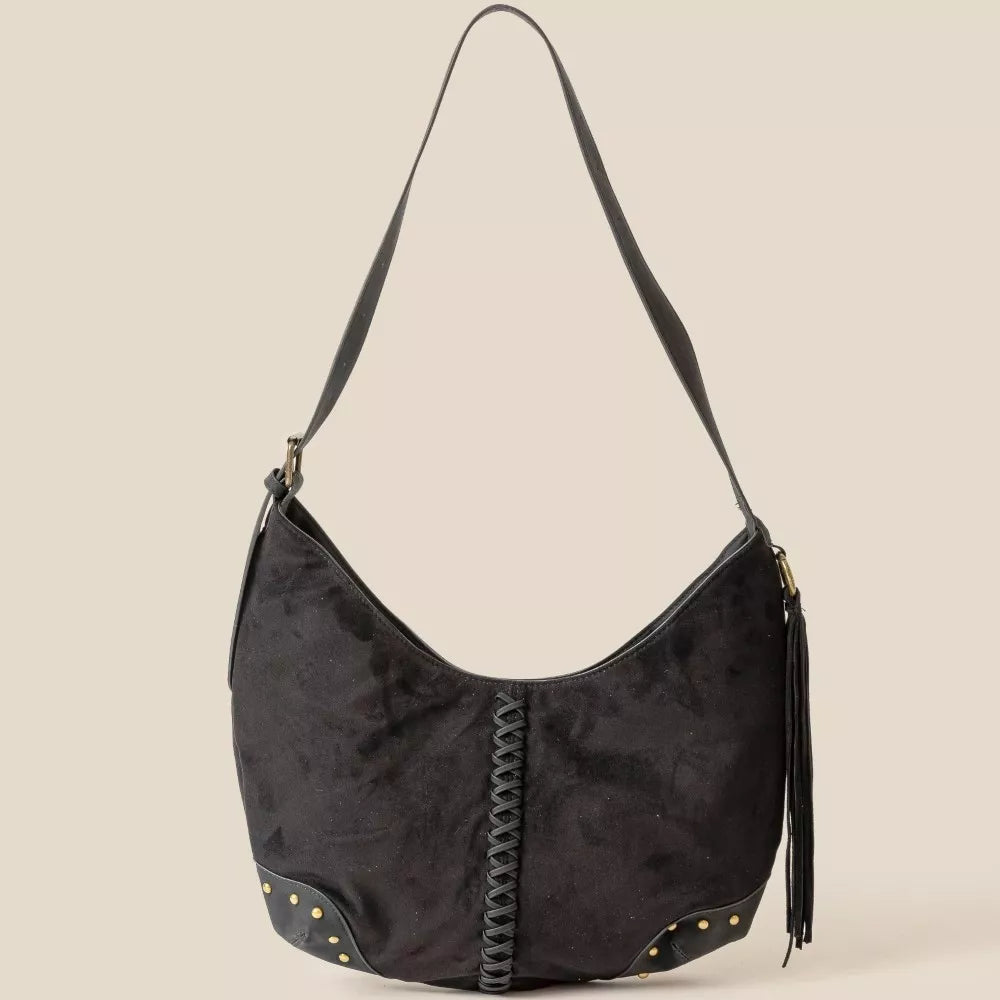 Black suede handbag with braided detail on a beige background