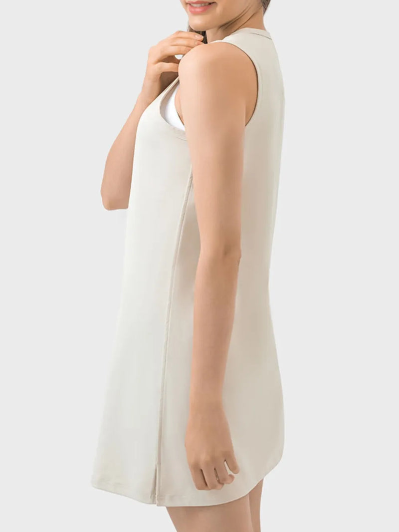 Woman wearing a white sleeveless dress on a plain background