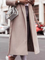 Person wearing a long beige coat on a city street