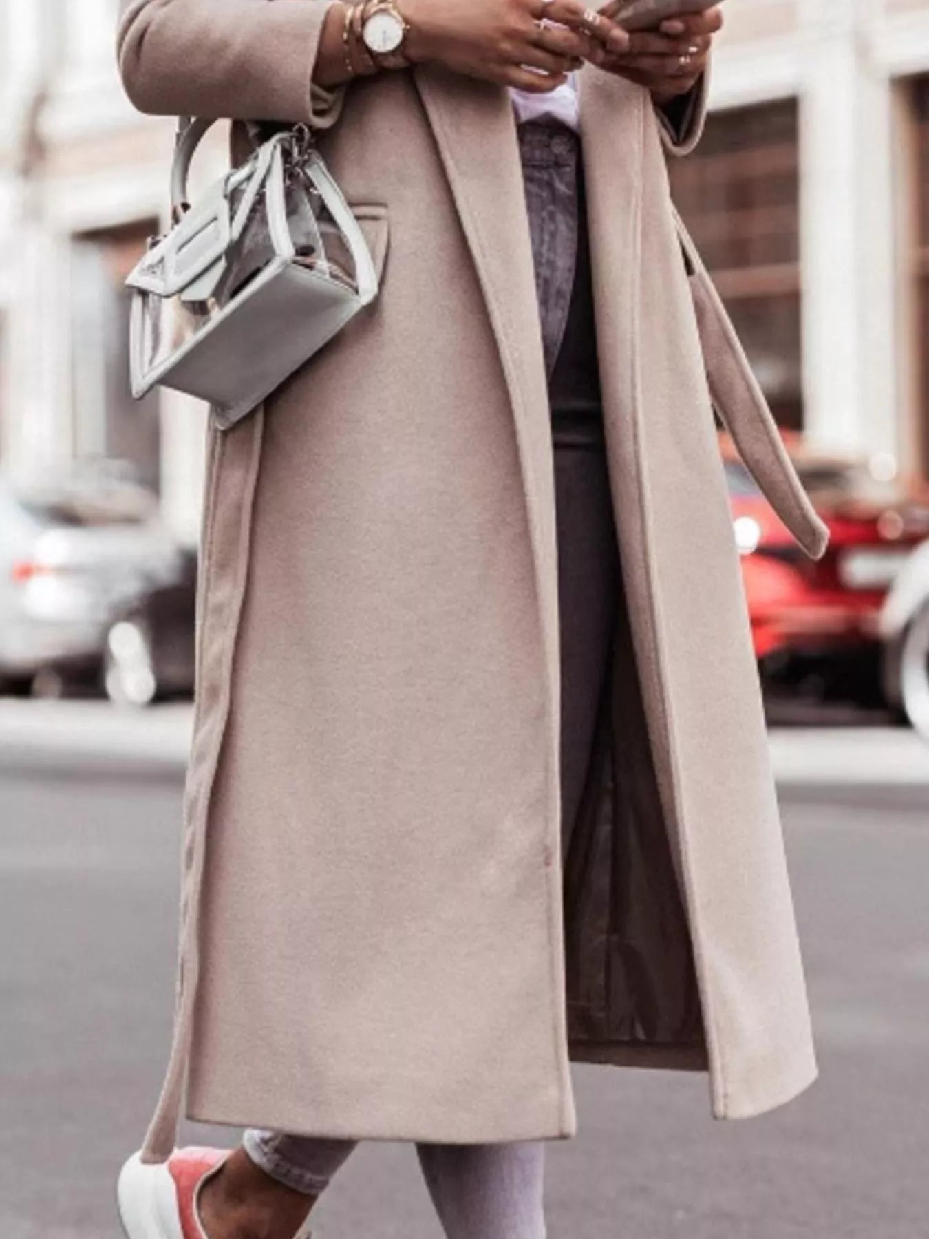 Person wearing a long beige coat on a city street