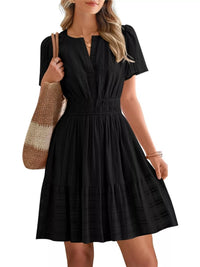 Woman wearing a black dress holding a striped bag on a white background