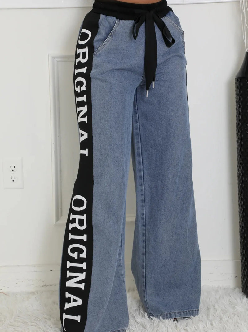 Blue jeans with 'ORIGINAL' text on a black strip against a white background