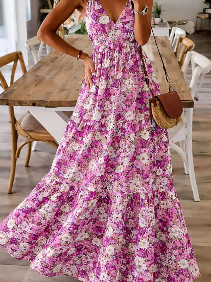 Woman wearing a floral dress in a home setting with wooden furniture.