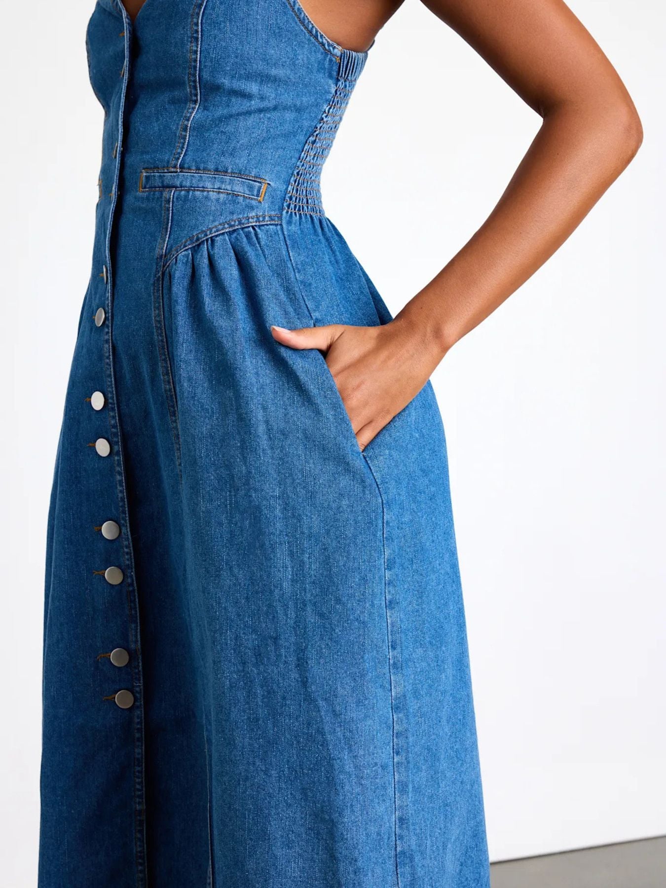Blue denim dress with buttons on a white background