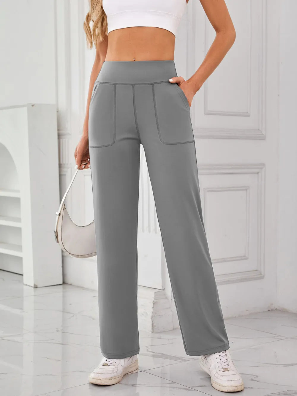 Person wearing gray high-waisted pants with a white background