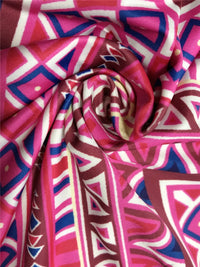 Roll of fabric with pink, blue, and white geometric pattern